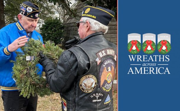 two veterans holding a wreath