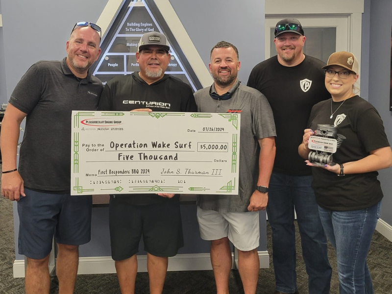 Group holding large check for Operation Wake Surf